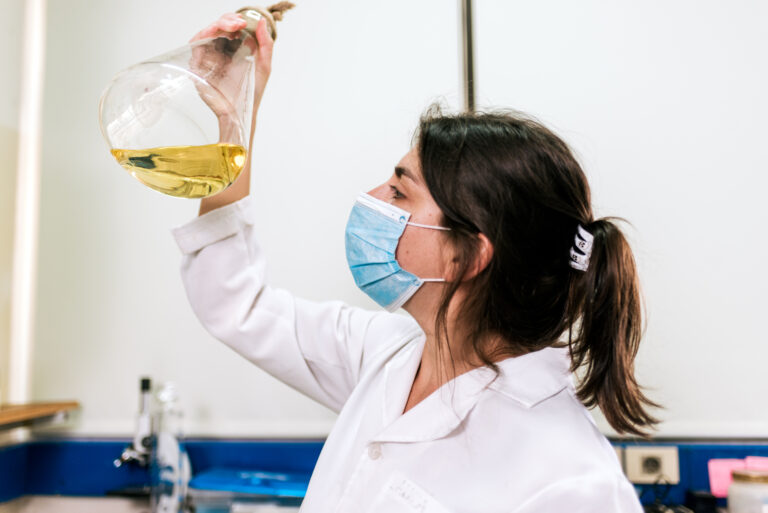 Stock photo of female scientist wearing face mask working in the laboratory.